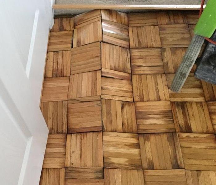 buckled hard wood flooring with equipment
